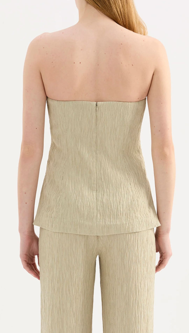 Beige pleated corset top with matching wide-leg trousers.