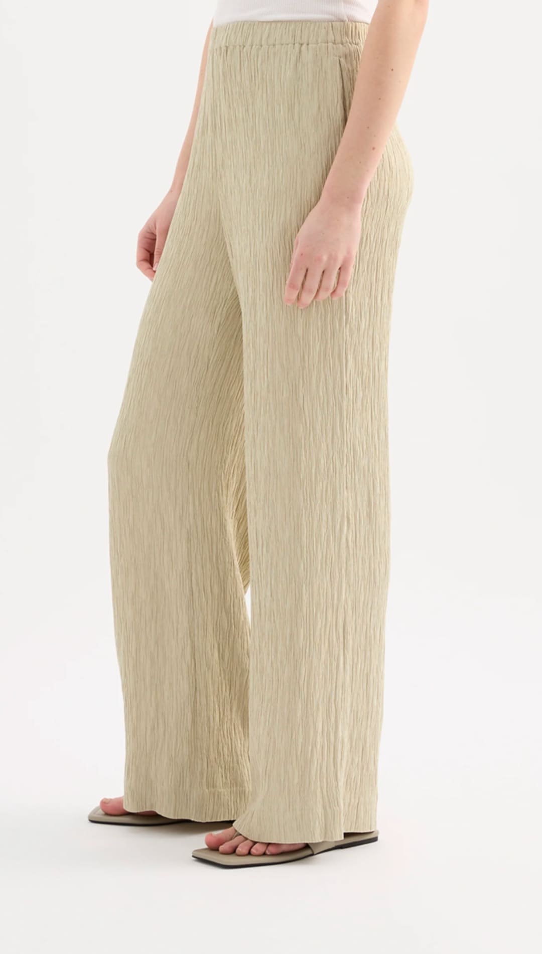 Beige pleated wide-leg trousers with a relaxed fit and elastic waistband.