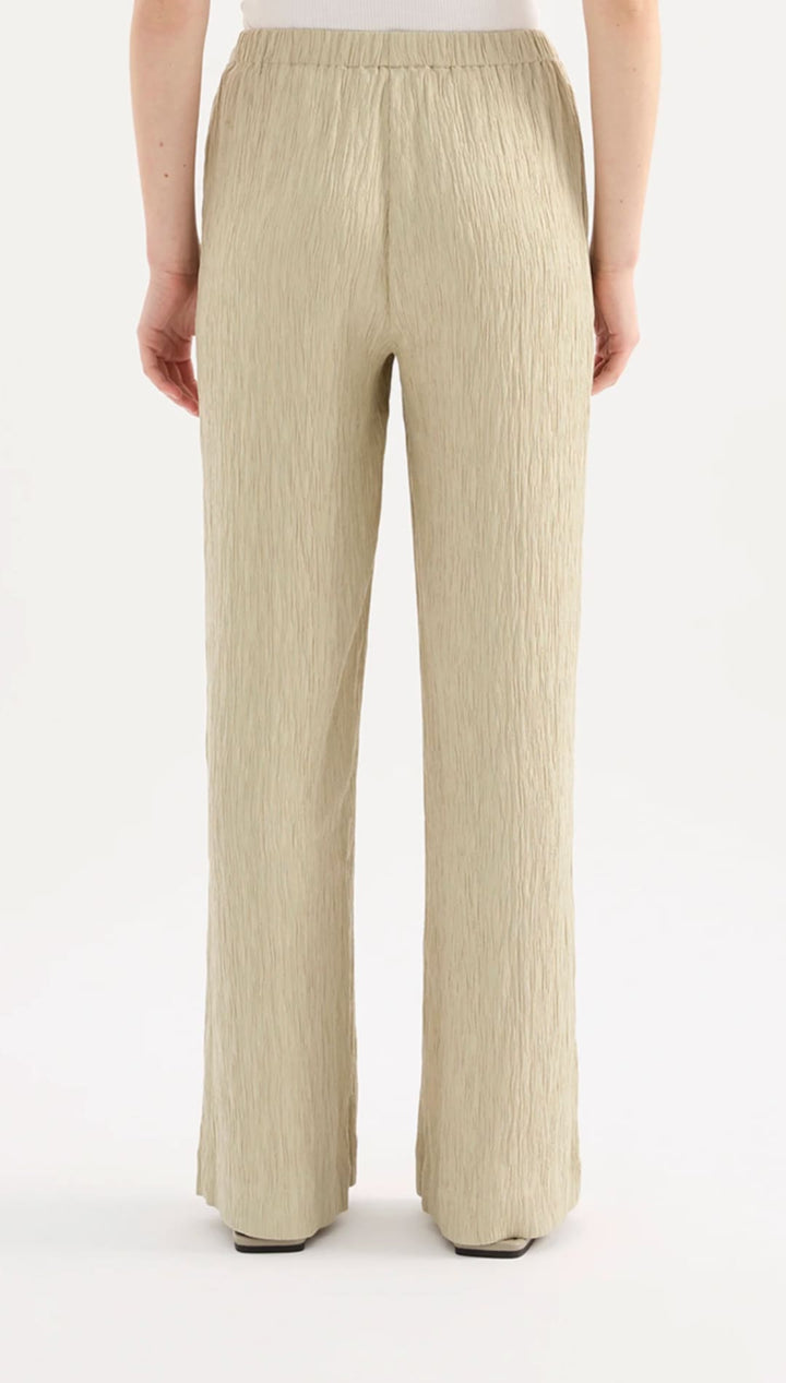 Beige pleated wide-leg trousers with an elastic waistband.