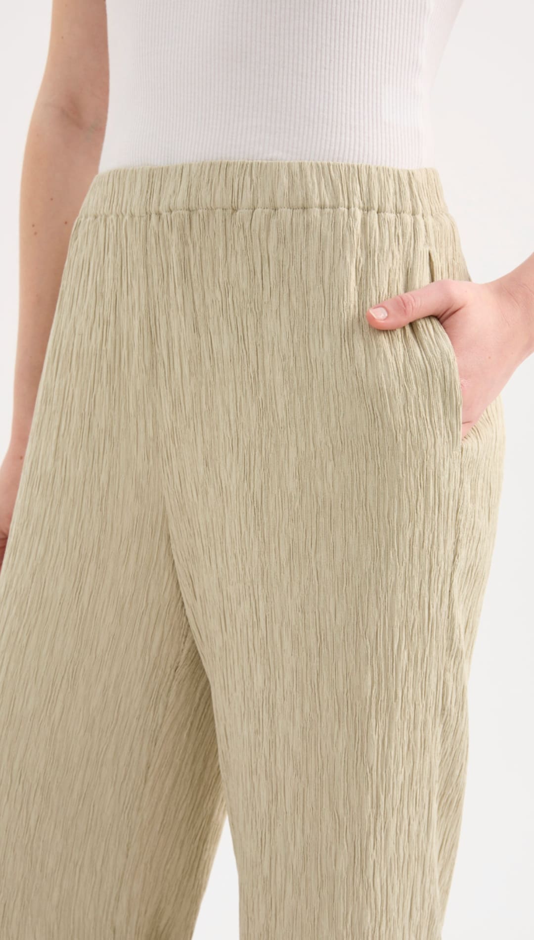 Beige pleated wide-leg trousers with an elastic waistband.