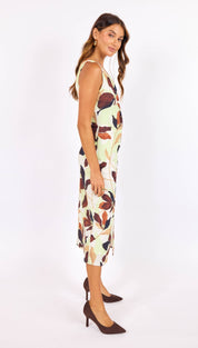 A sleeveless, knee-length dress in a light mint green fabric featuring an abstract leaf pattern with earthy brown and muted orange tones.