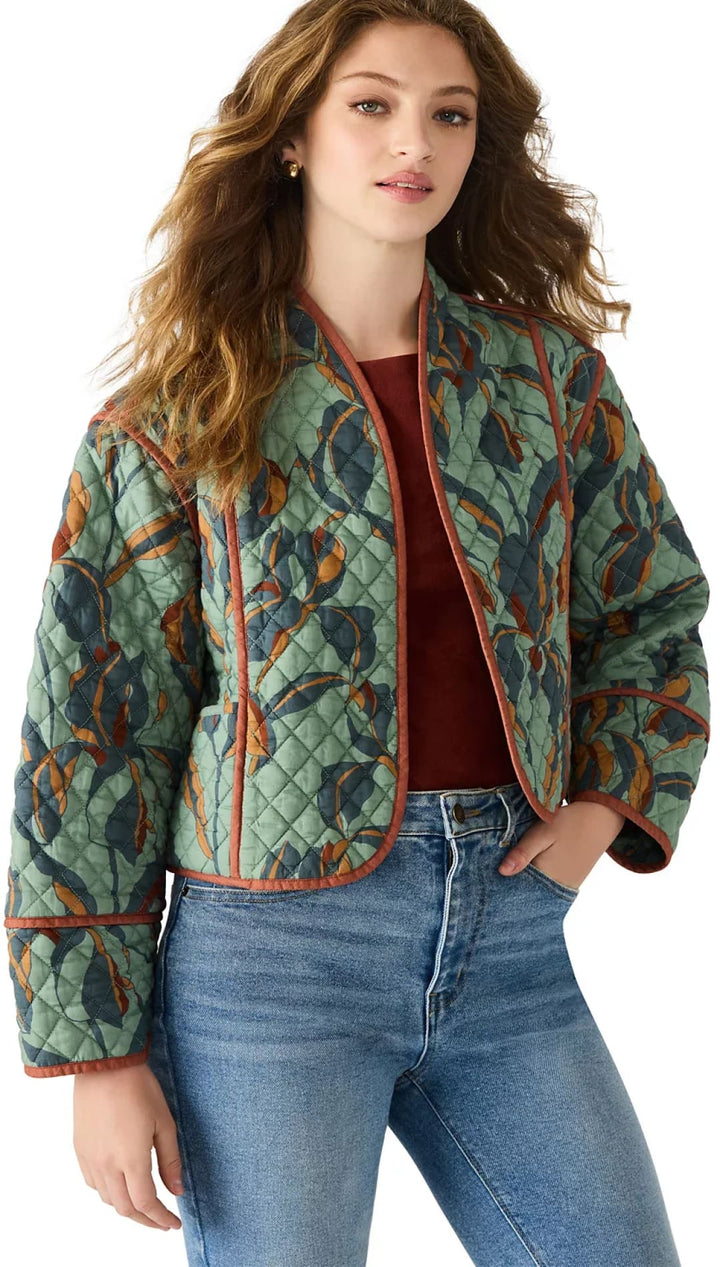 A quilted jacket with a green leaf pattern and burnt orange trim.