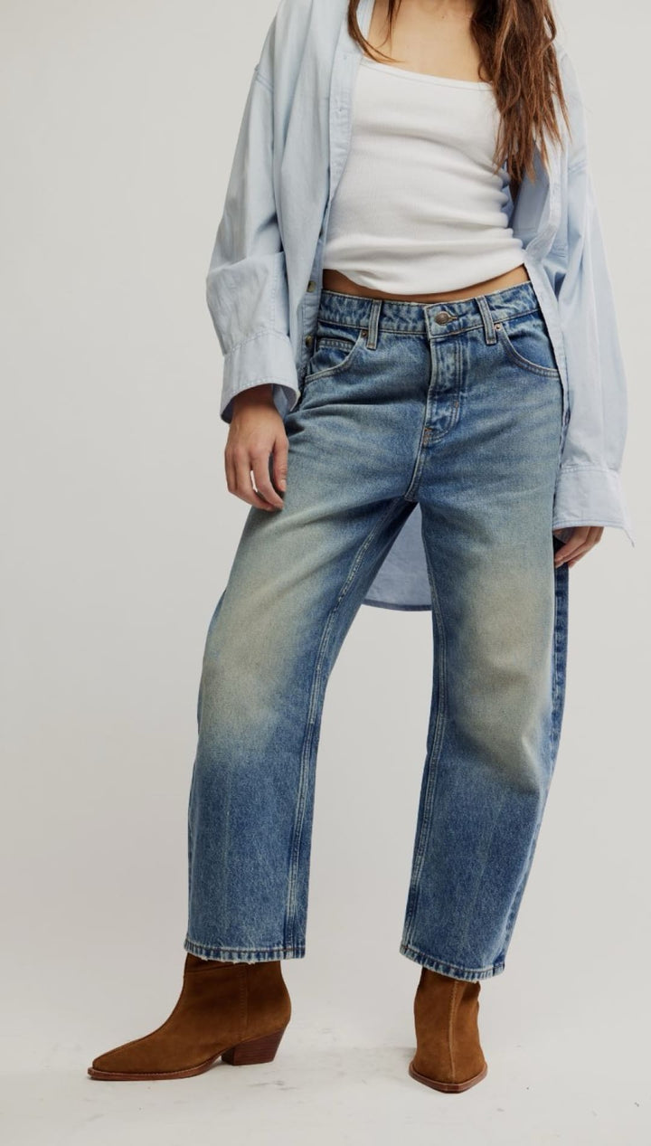 Distressed blue jeans with brown ankle boots.