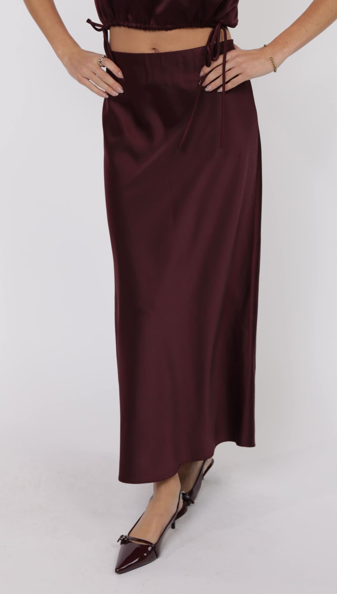 A long, flowy, burgundy satin skirt.