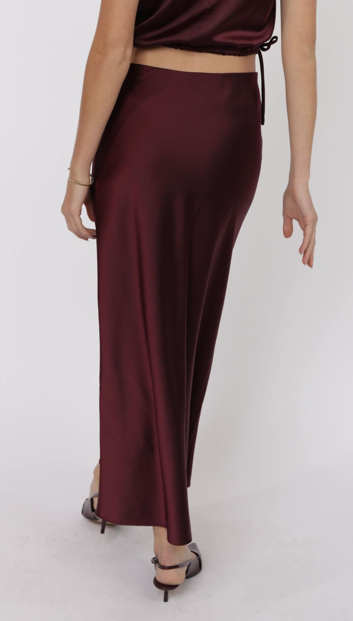 A women’s long burgundy satin slip skirt.