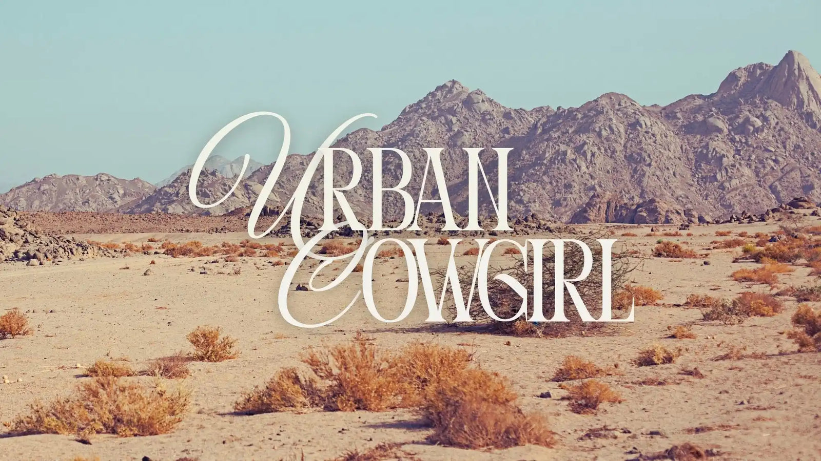 Desert landscape with ’Urban Cowgirl’ text.