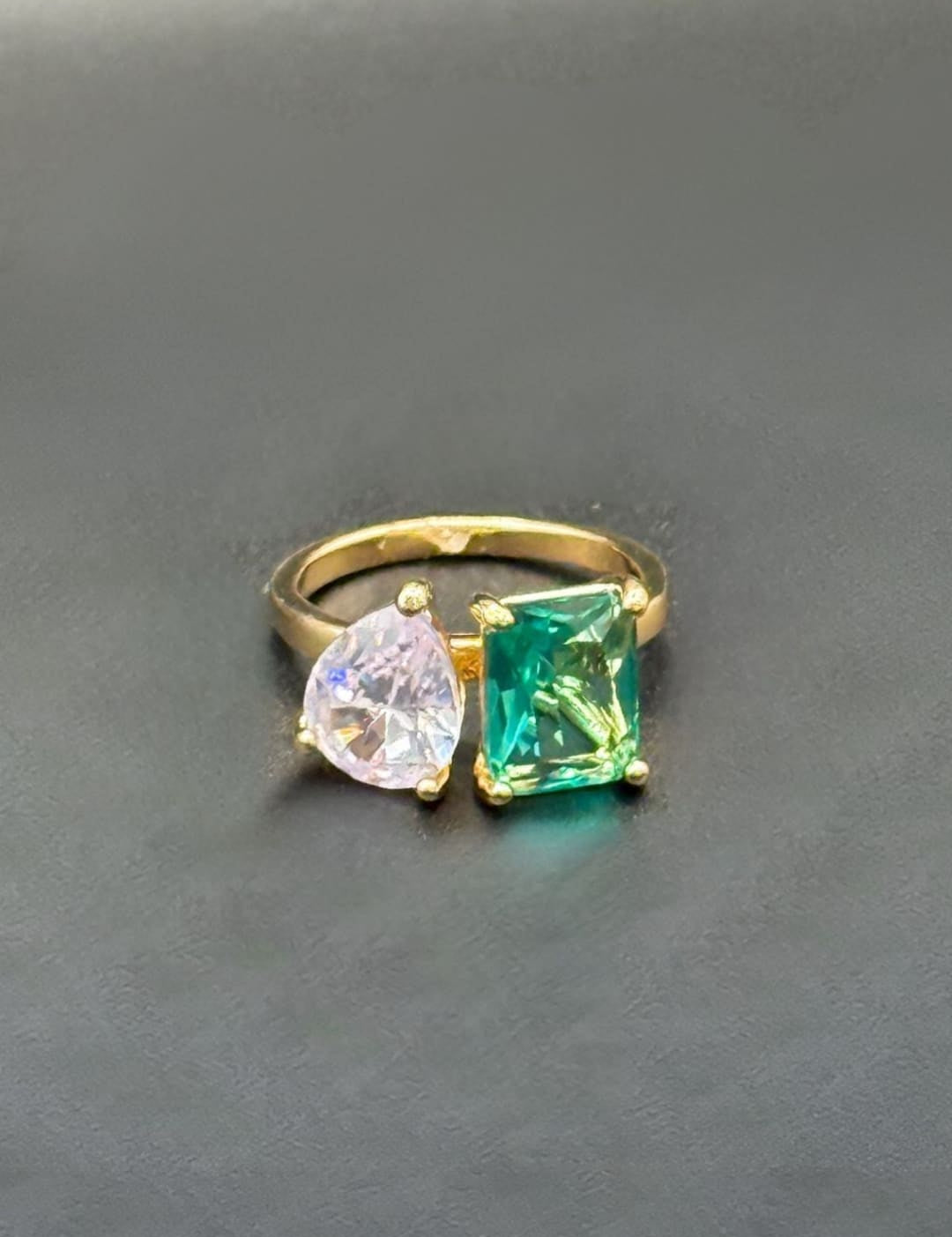Gold ring with green and pink gemstones.