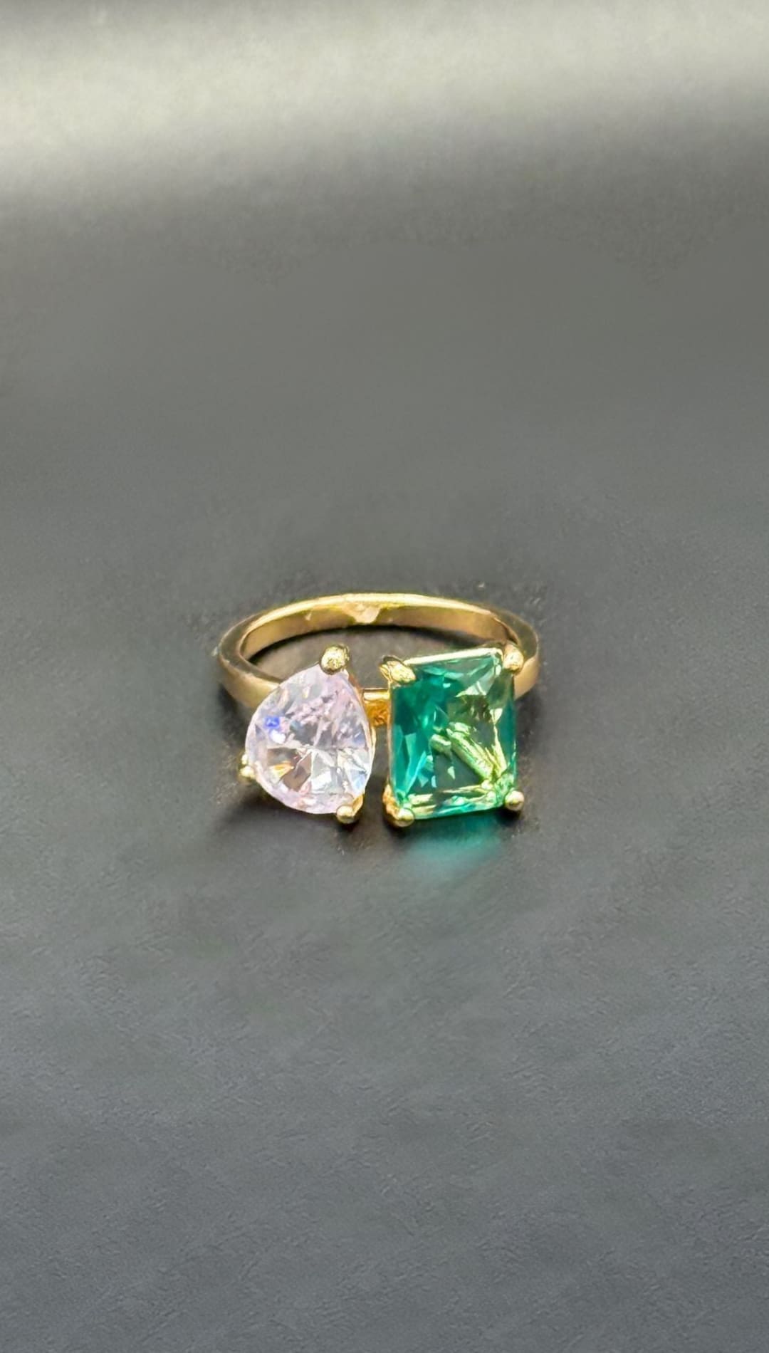 Gold ring with green and pink gemstones.