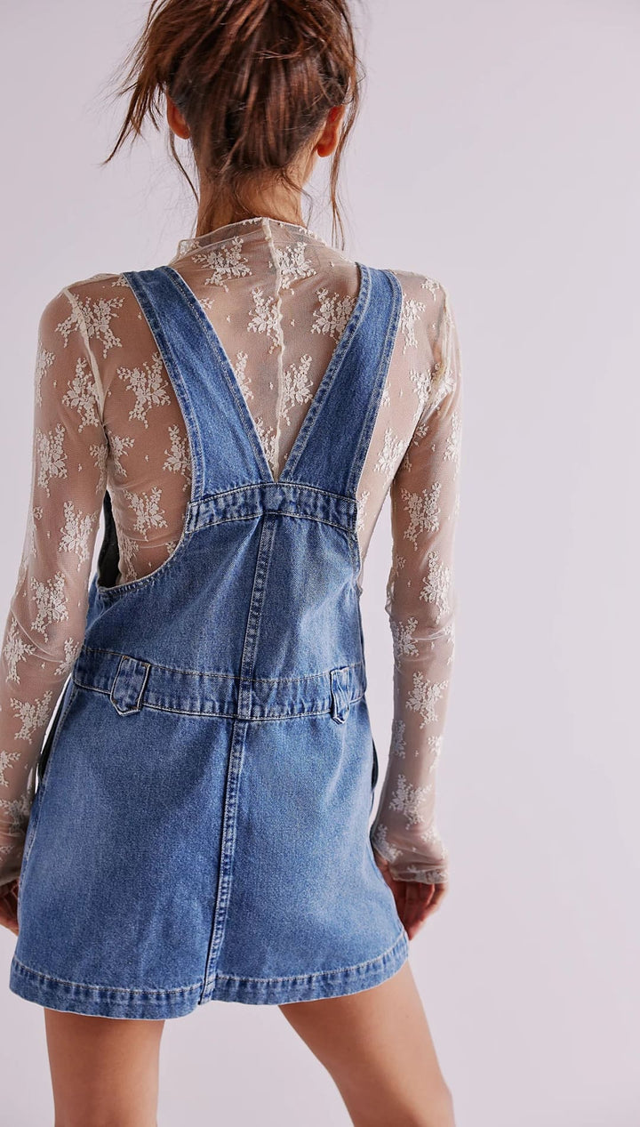 Denim overall dress with button closure and adjustable straps.