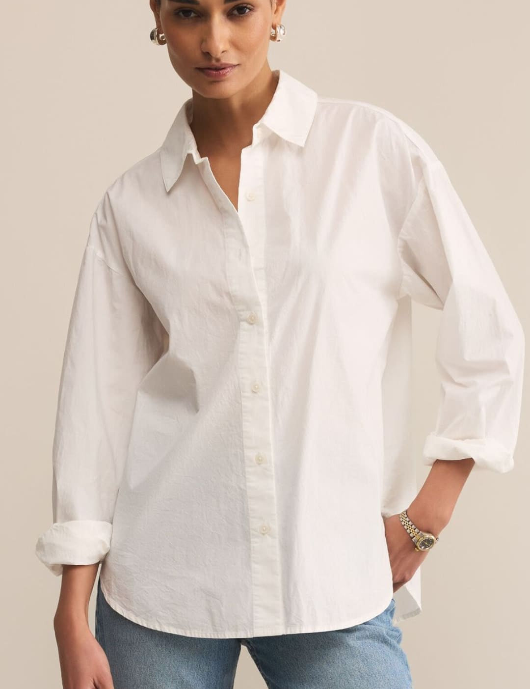 White oversized cotton shirt with rolled sleeves and button-down collar.