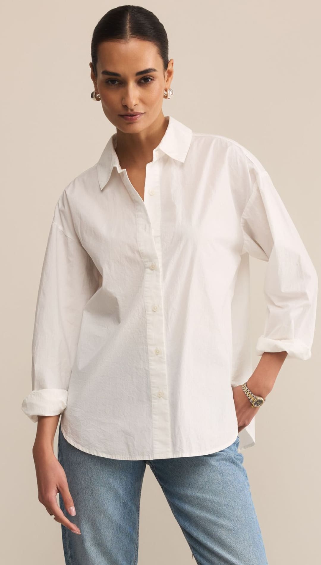 White oversized cotton shirt with rolled sleeves and button-down collar.