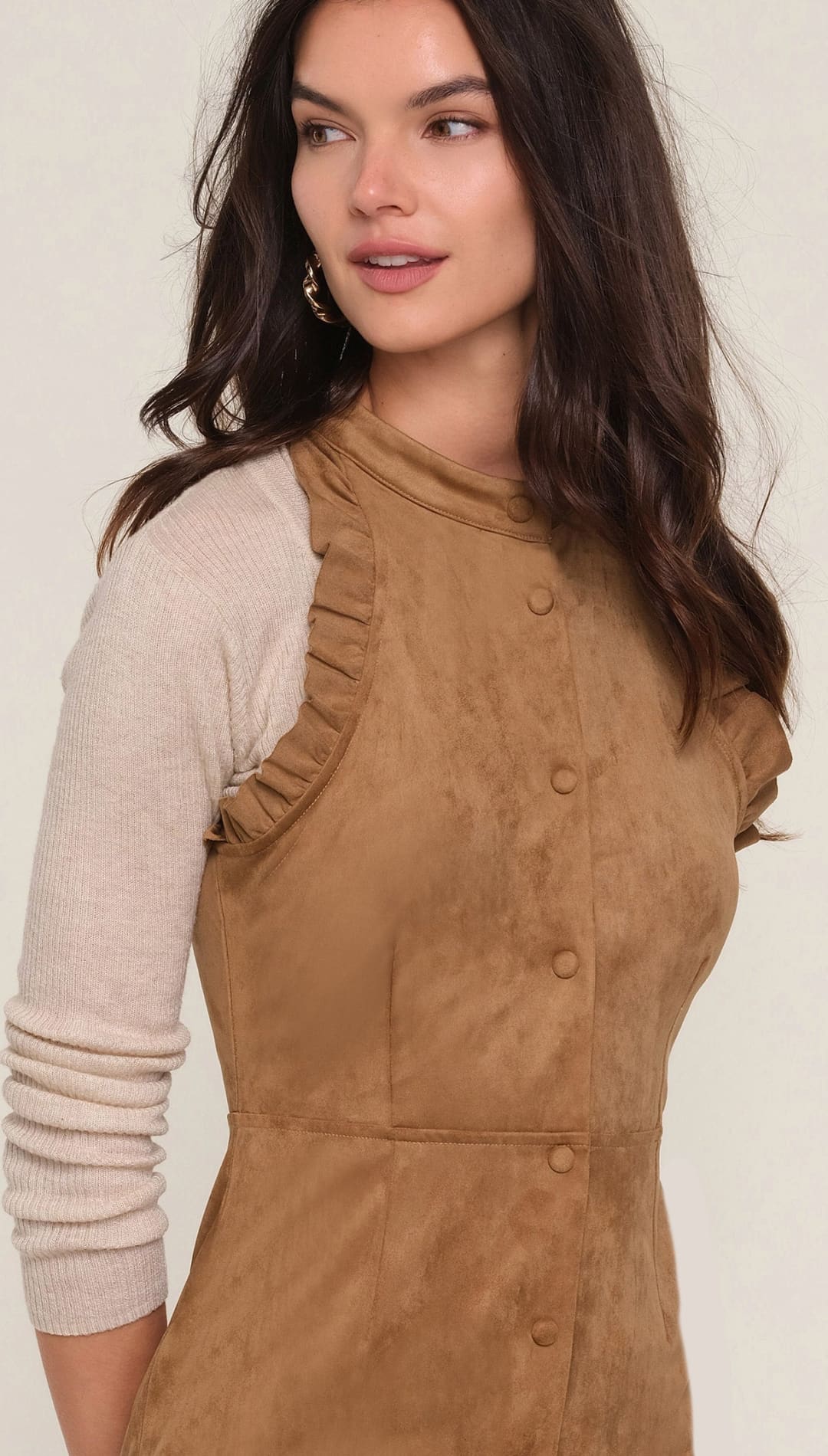 Brown corduroy sleeveless dress with ruffled neckline and button front closure.