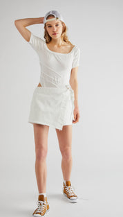 White wrap-style mini dress with cut-out details and a ruffled hem