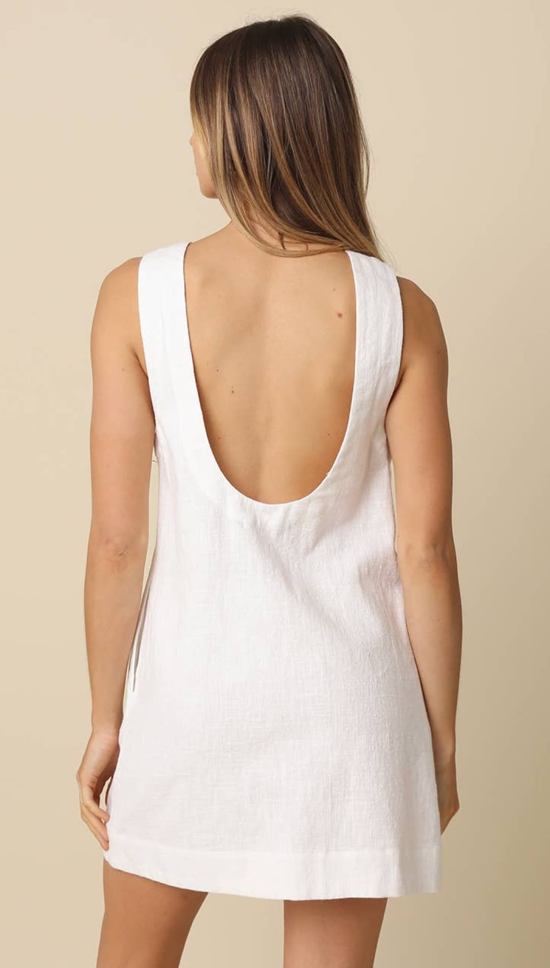 White sleeveless dress with a deep back cutout and relaxed fit