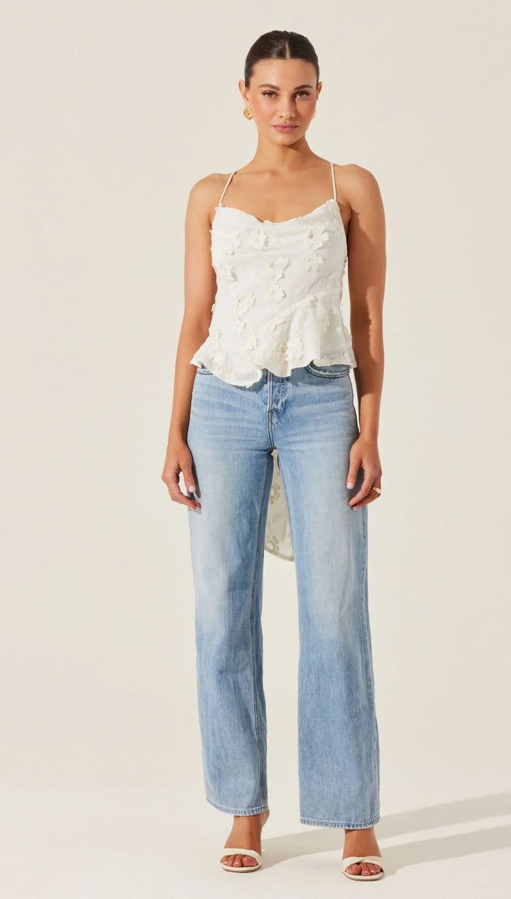 Woman in white top and light blue jeans.