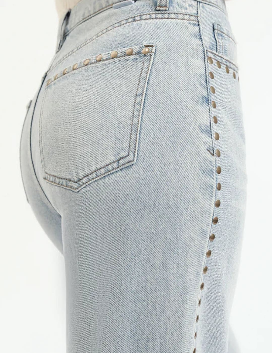 Light-wash denim jeans with studded side seams.