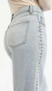 Light-wash denim jeans with studded side seams.