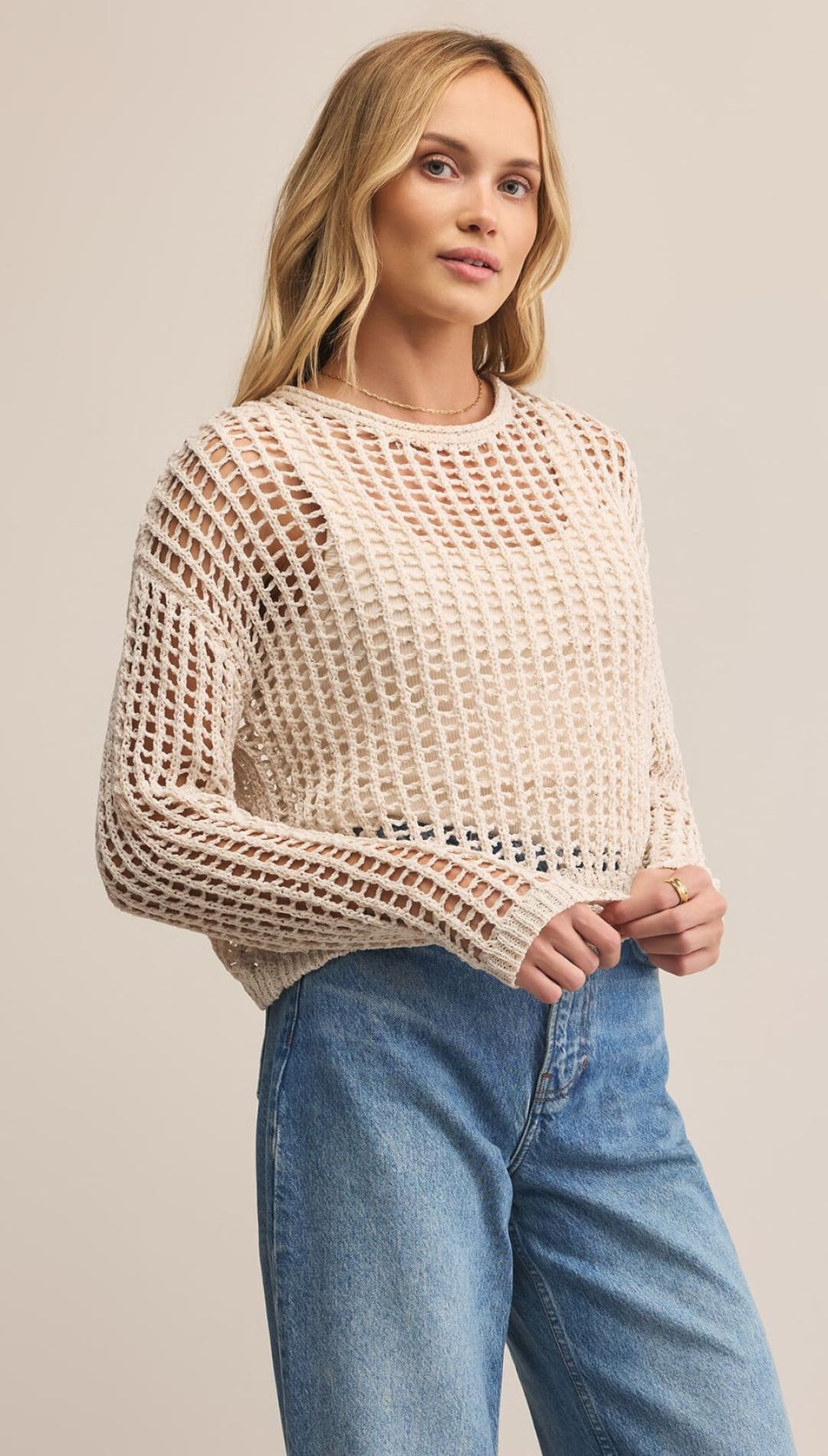 Women’s cream-colored open-knit long-sleeve sweater.