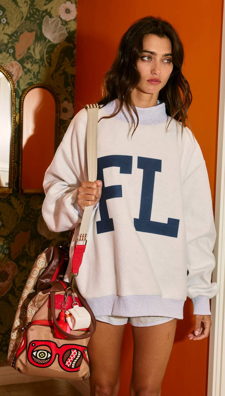 White oversized sweatshirt with blue ’fl’ letters and turtleneck design.