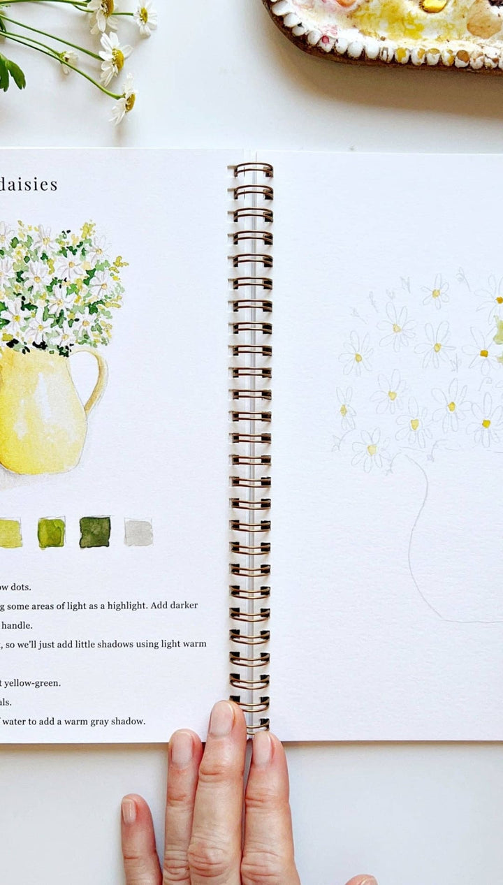 Watercolor painting book with yellow vase and white flowers design, spiral binding.