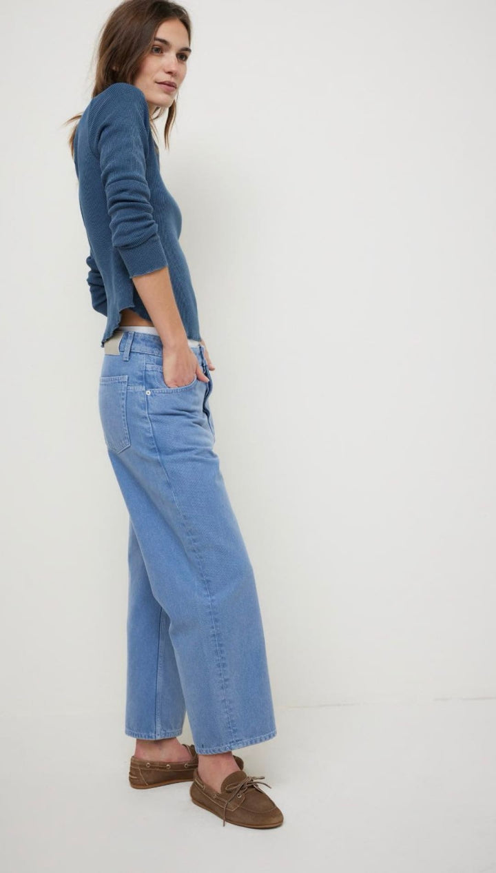 Woman wearing blue jeans and a blue top.