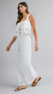 White lace-trimmed jumpsuit with a tie-front top and wide-leg pants.