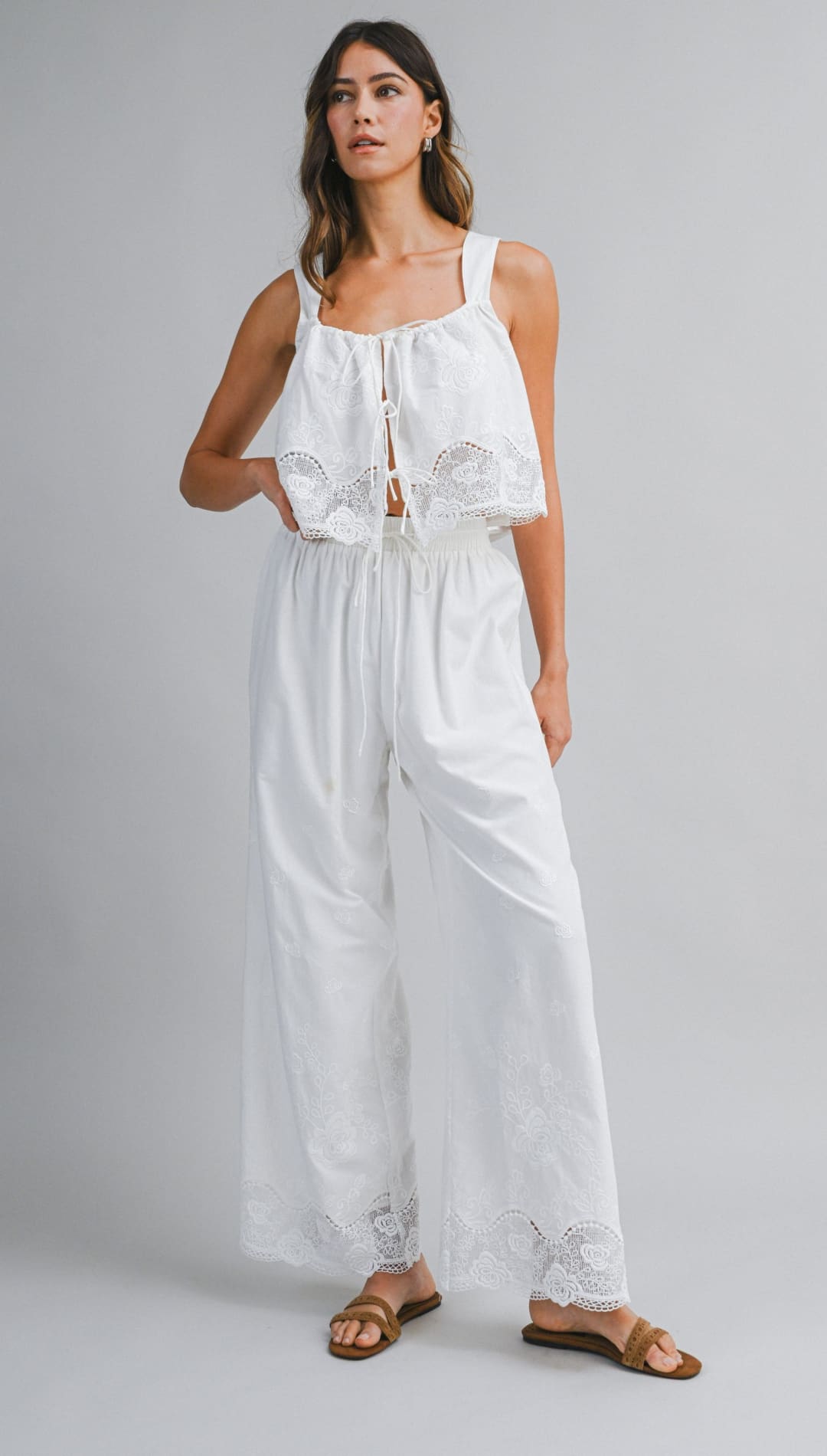 White lace-trimmed sleeveless top with a square neckline and front tie detail.