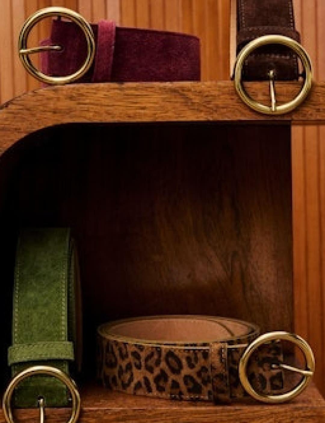 Five assorted belts with gold-tone round buckles.