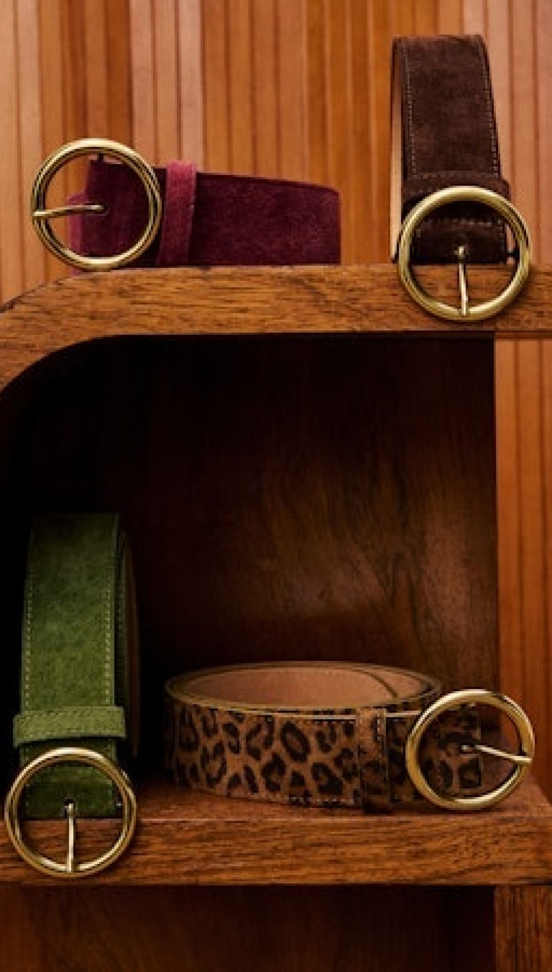 Five assorted belts with gold-tone round buckles.