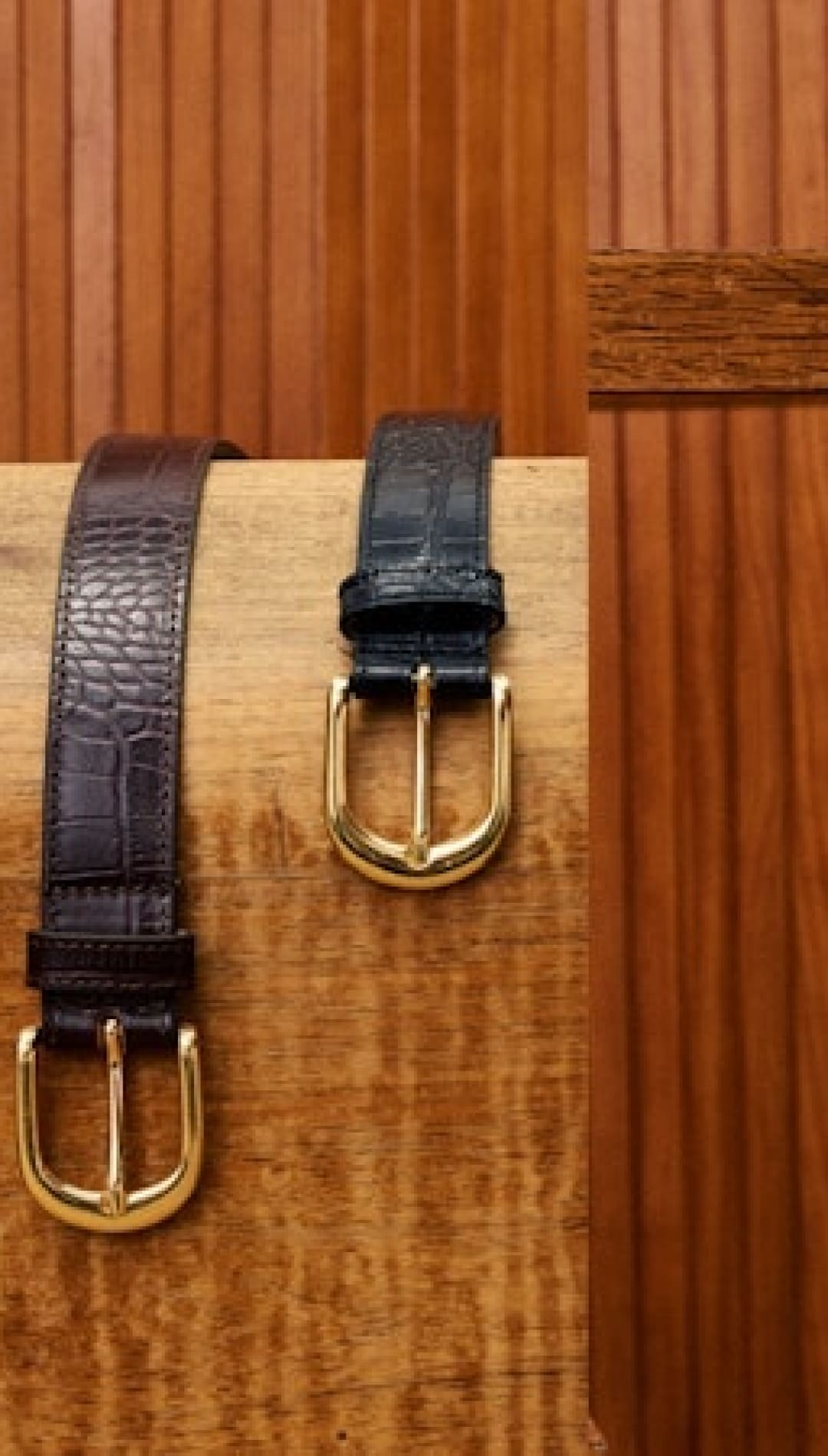 Two leather belts with gold buckles