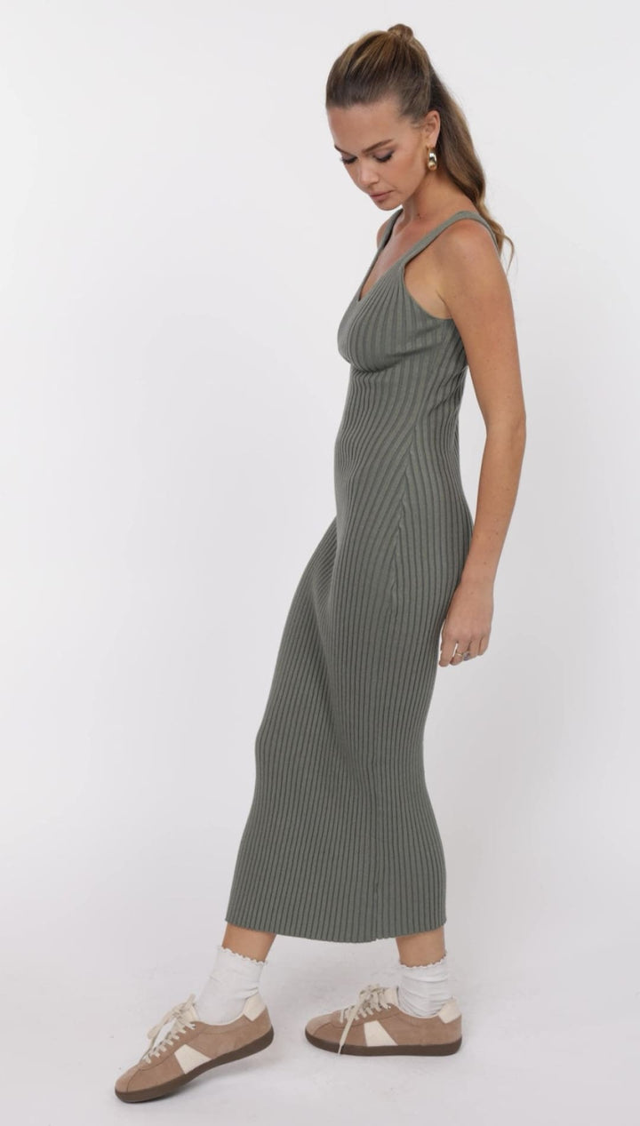 Woman in a ribbed, olive-green dress.