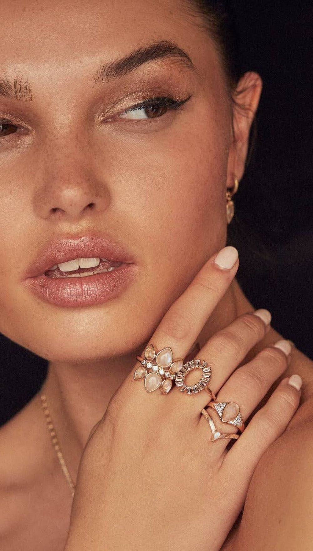 Woman’s hand adorned with three rings.