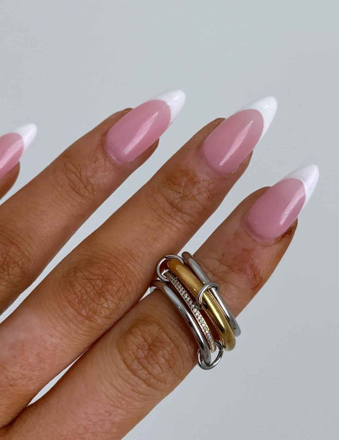 A stack of three interlocking rings in silver and gold tones with a textured band.