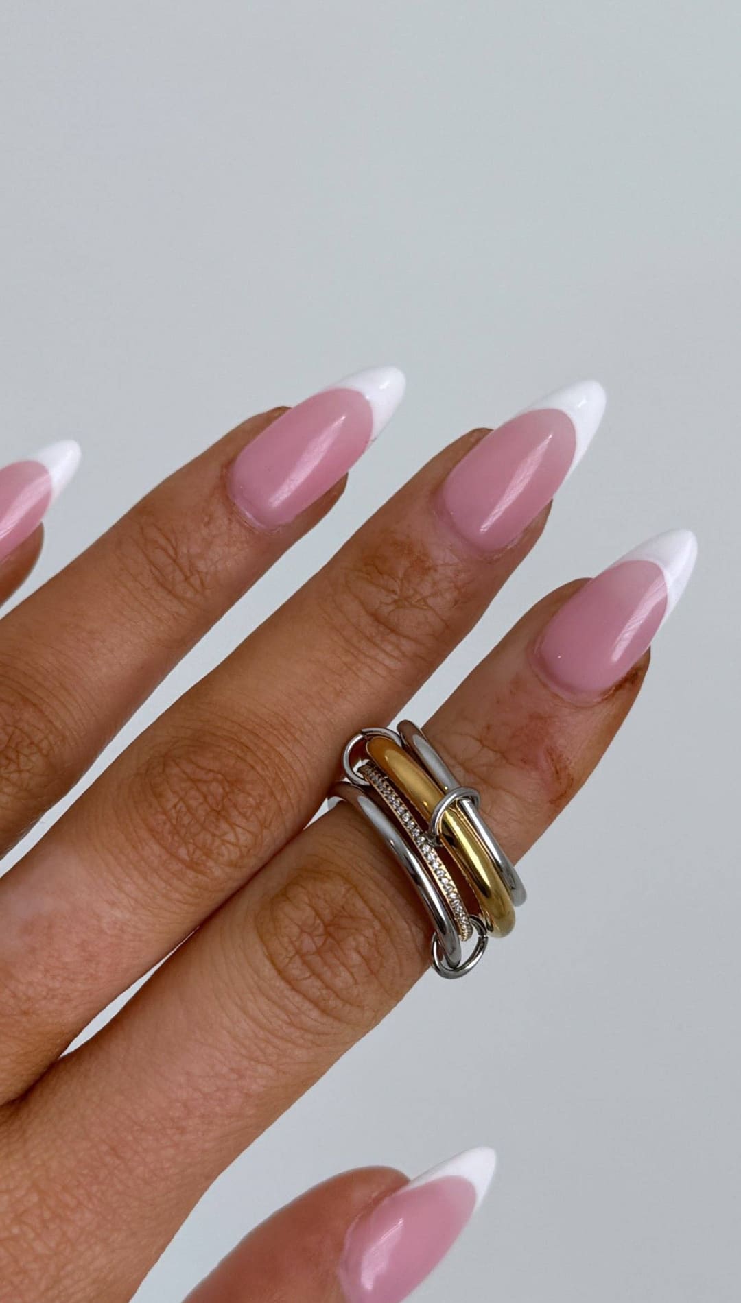 A stack of three interlocking rings in silver and gold tones with a textured band.