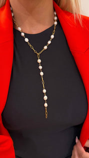 A delicate gold chain necklace adorned with evenly spaced, lustrous white pearls.