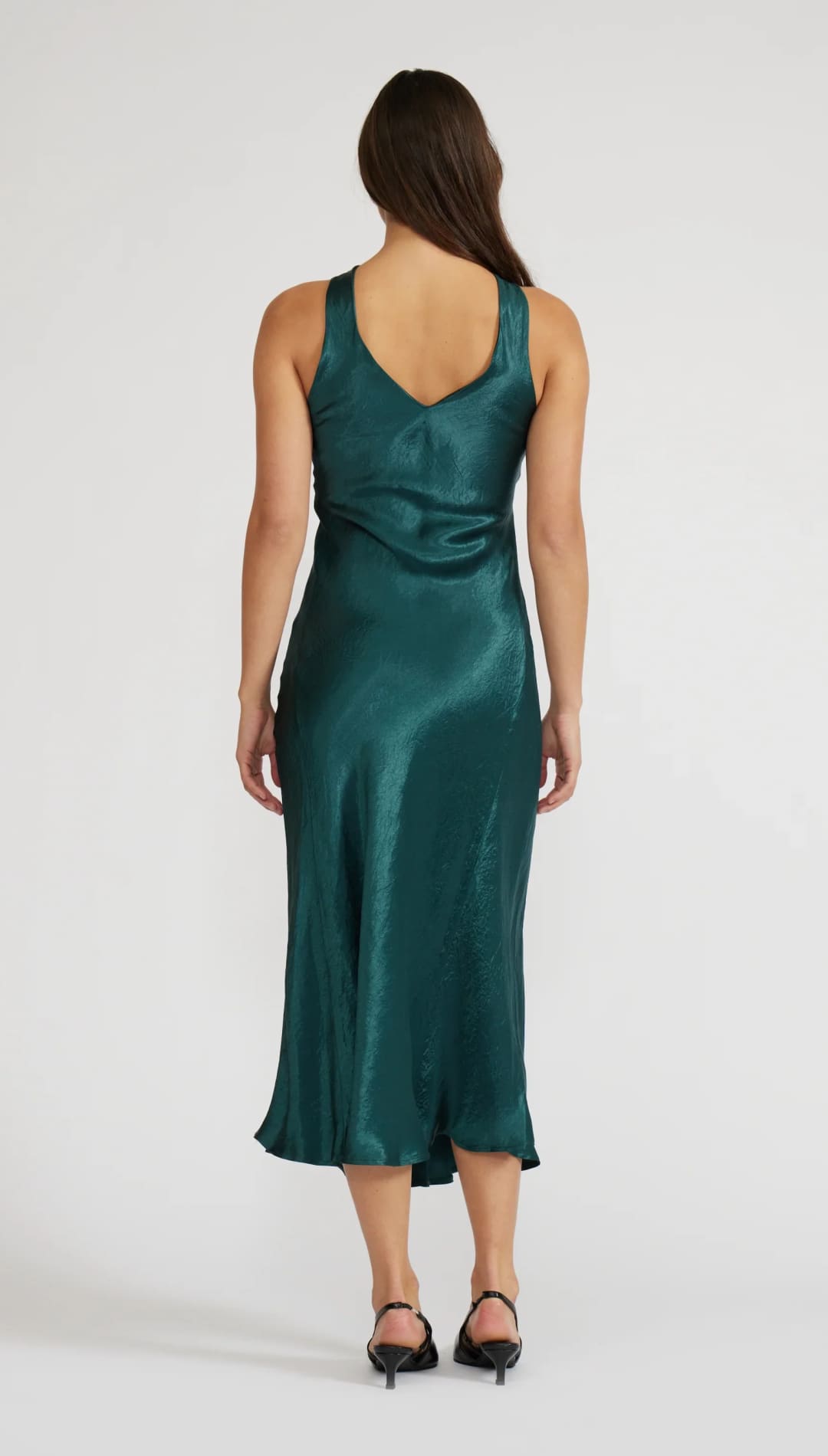 Emerald green satin slip dress with a draped back design and thin straps.emerald green satin slip dress with draped back and thin straps.