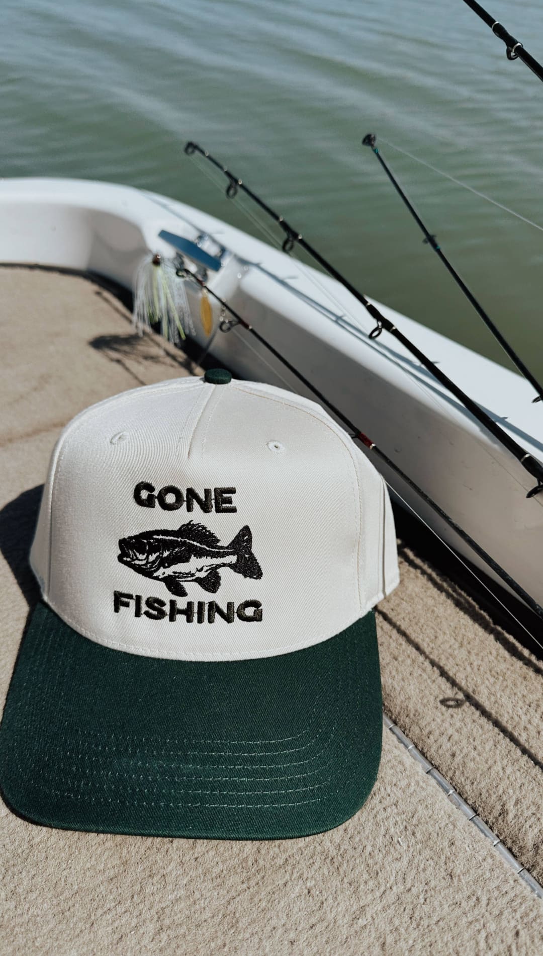 White and green two-tone baseball cap with black embroidered ’gone fishing’ text and fish graphic.