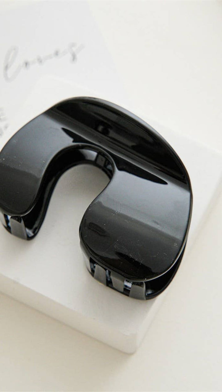 Black glossy mouth guard with adjustable strap and clip design.
