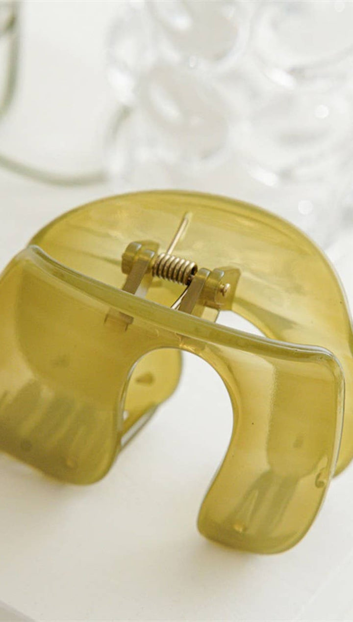 Yellow transparent plastic dental mouth guard with metal screw and spring mechanism.