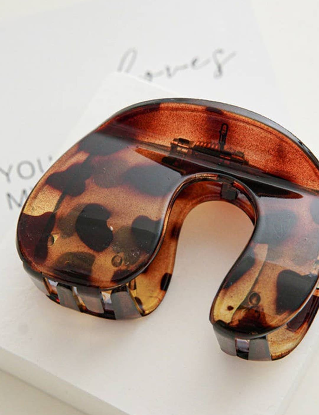 Tortoiseshell neck pillow with metallic accents, designed for travel comfort.