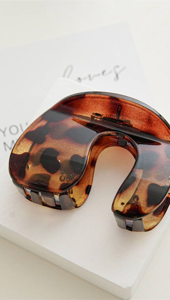 Tortoiseshell neck pillow with metallic accents, designed for travel comfort.