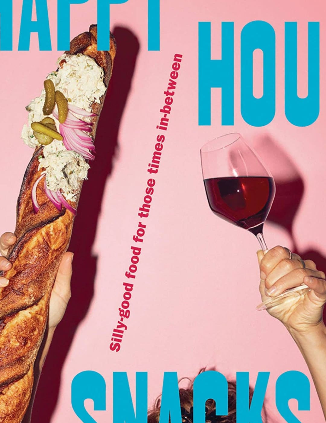 Pink background with a baguette and wine glass in hands.