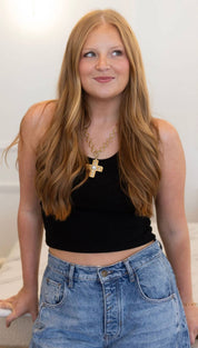 Gold cross necklace with a chain.