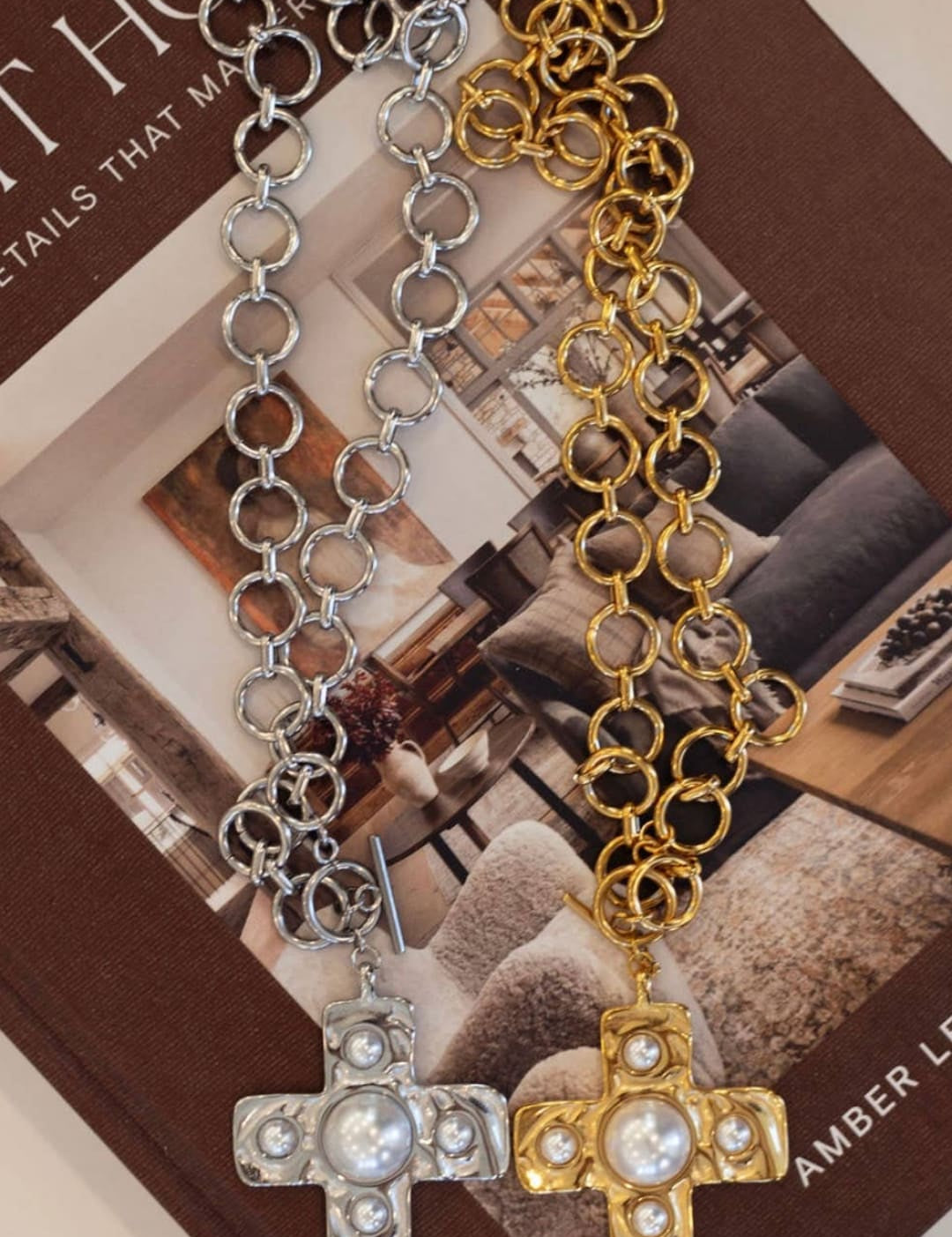 Silver and gold chain necklaces, each featuring a cross pendant adorned with pearls.