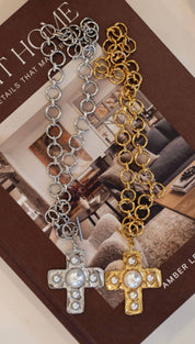 Silver and gold chain necklaces, each featuring a cross pendant adorned with pearls.