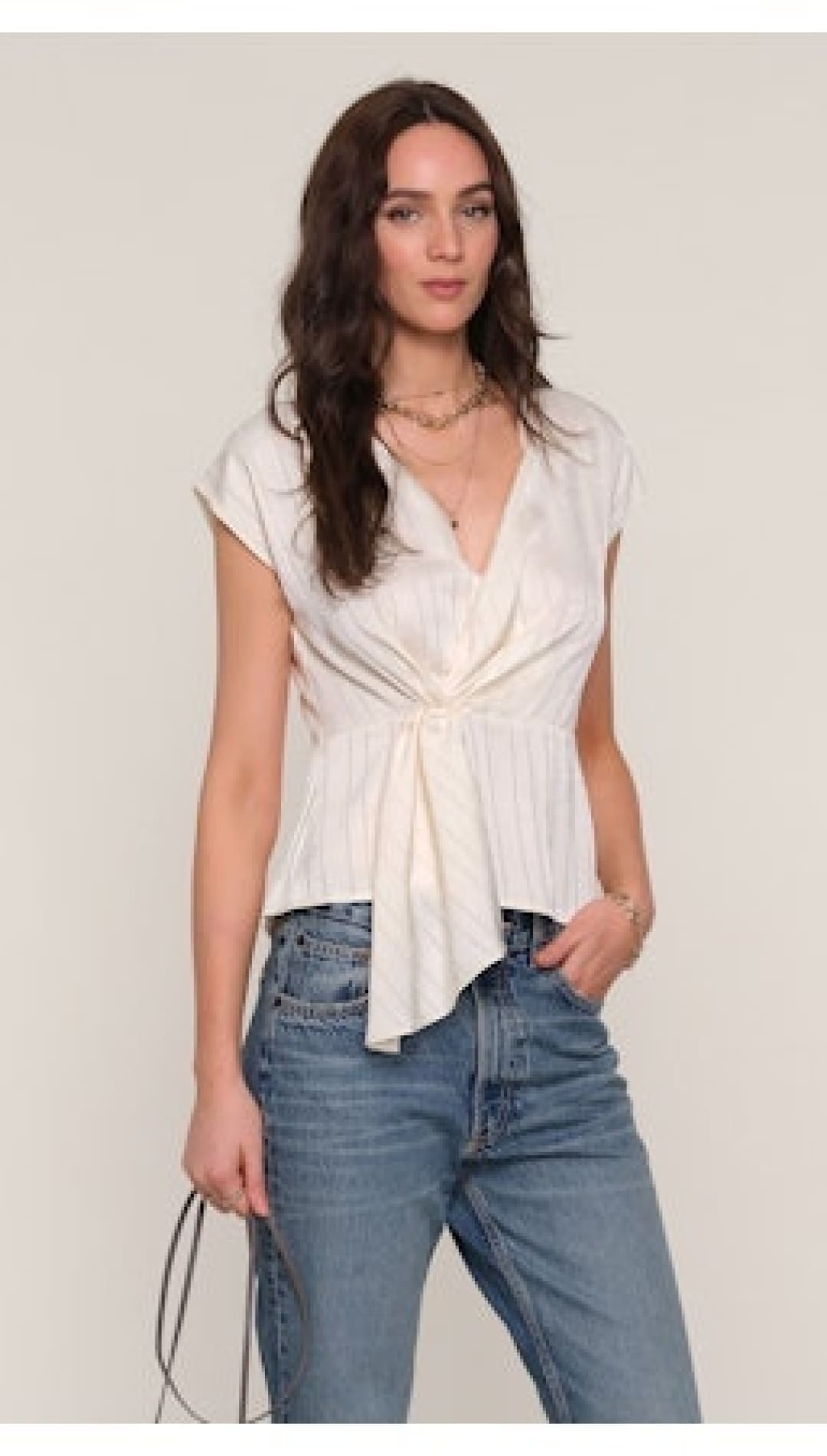 Women’s off-white V-neck cap-sleeve top with a cinched, tie-front detail.