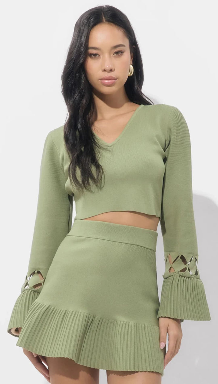 Olive green ribbed knit two-piece set with ruffled hem and bell sleeves.
