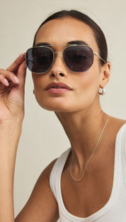 Gold-framed octagonal sunglasses with dark lenses.