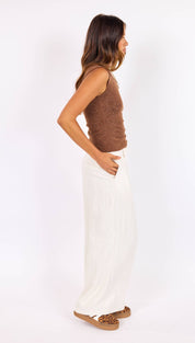 A brown, textured knit sleeveless top worn by a woman.