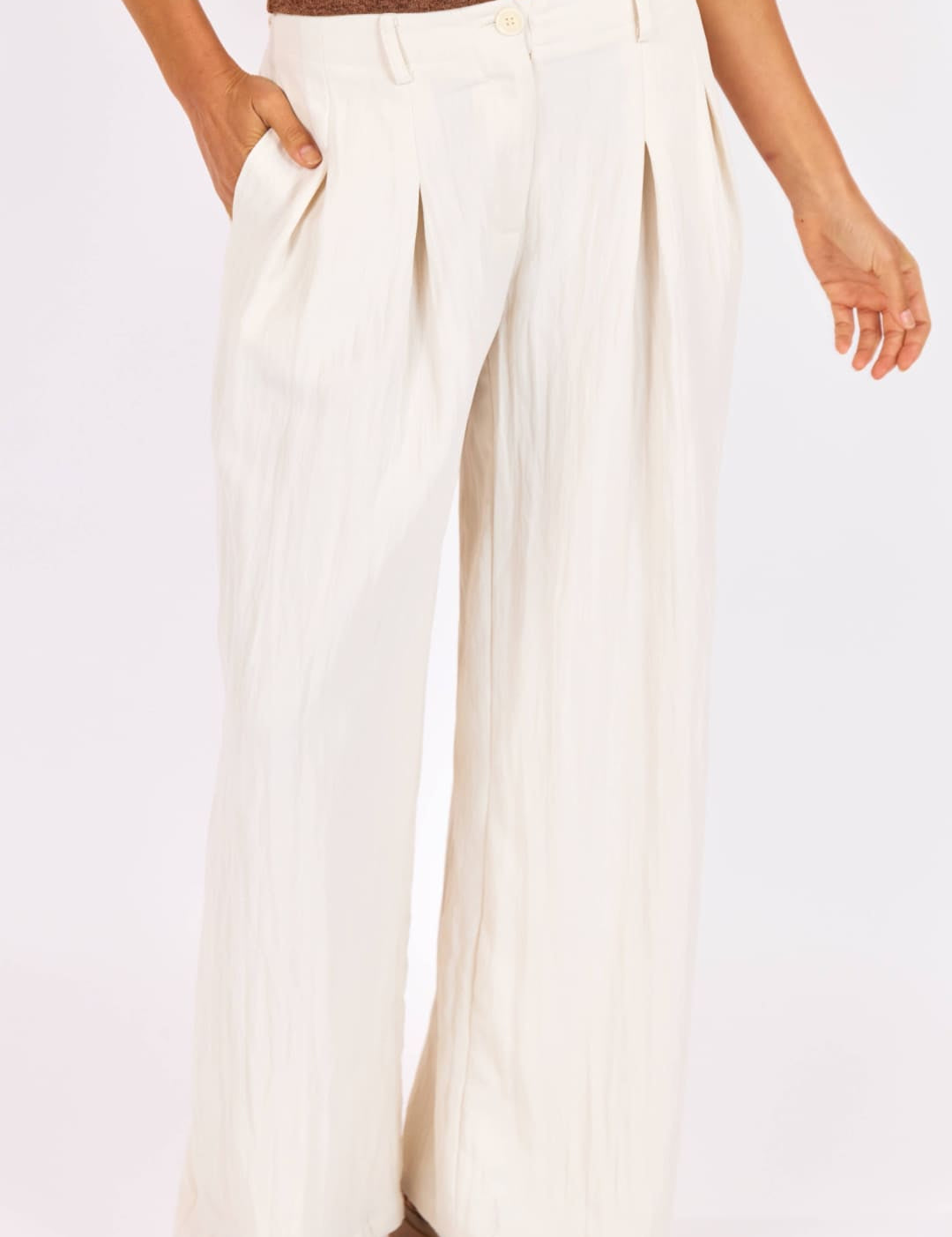 Cream-colored wide-leg trousers with a pleated front and button closure.